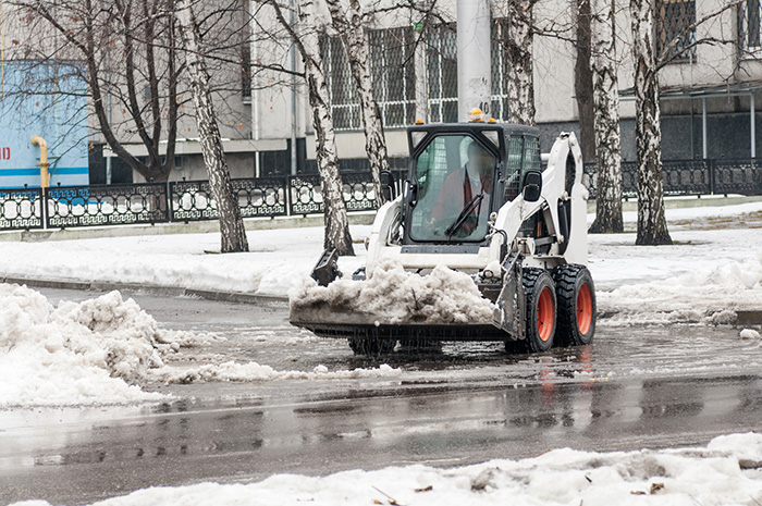 loader removing snow outside on the street